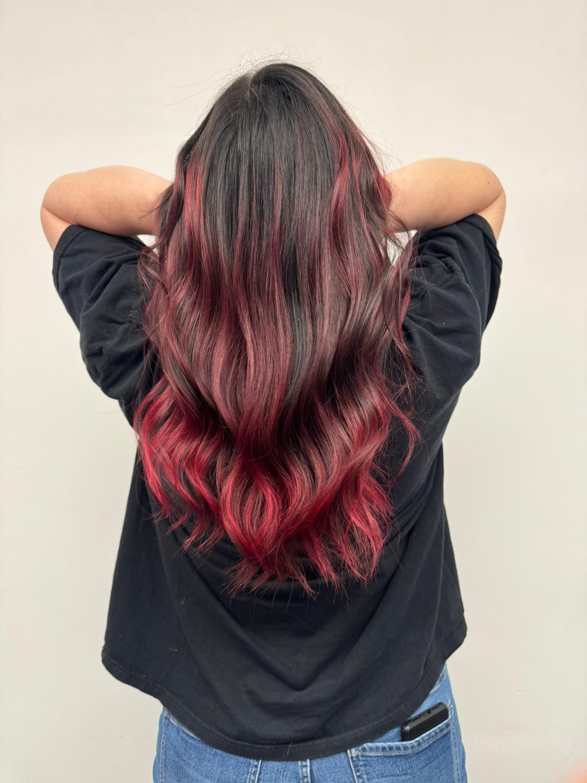 Klant met prachtig golvend haar in rood-zwarte balayage, gestyled bij High Hair.